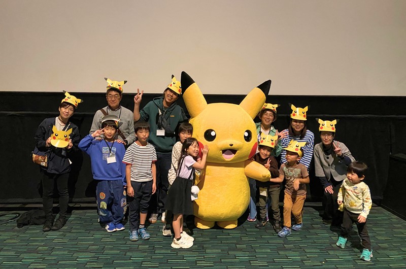 ピカチュウと記念撮影を行う子どもたちとスタッフ