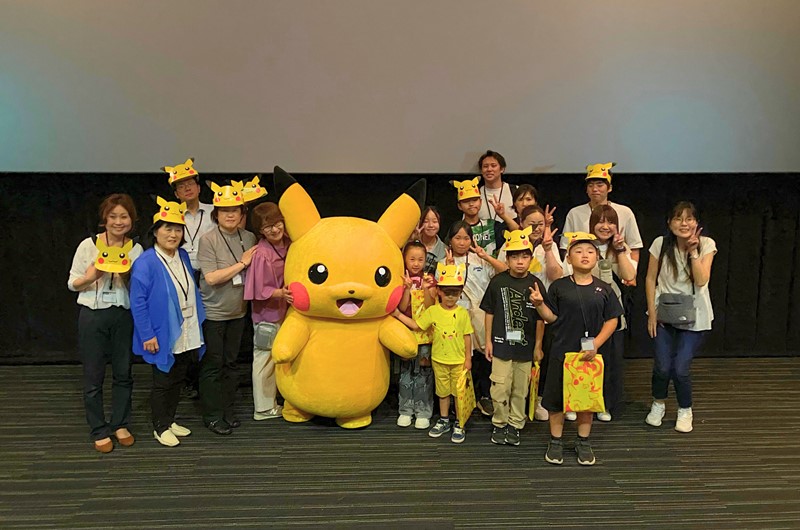ピカチュウと記念撮影を行う子どもたちとスタッフ